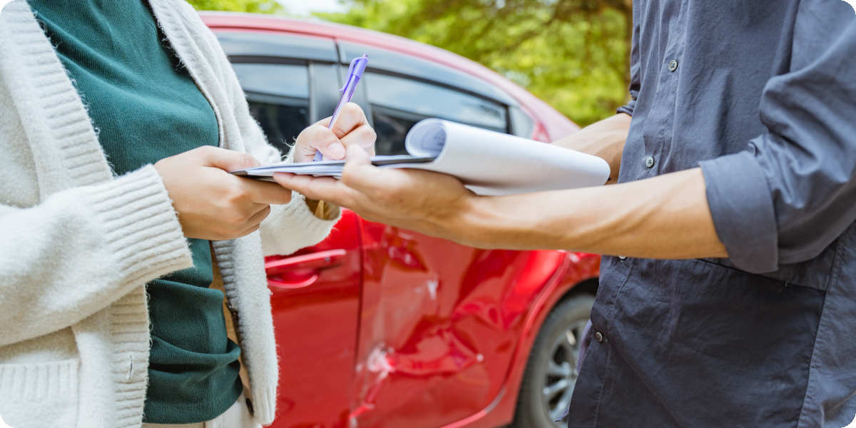Ein Schaden bei einem roten Leasingauto wird von einem Gutachter bewertet.